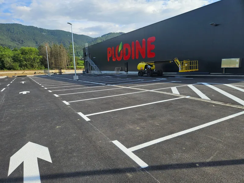 Iscrtano parkiralište trgovačkog centra sa strelicama smjera i pješačkim prijelazom